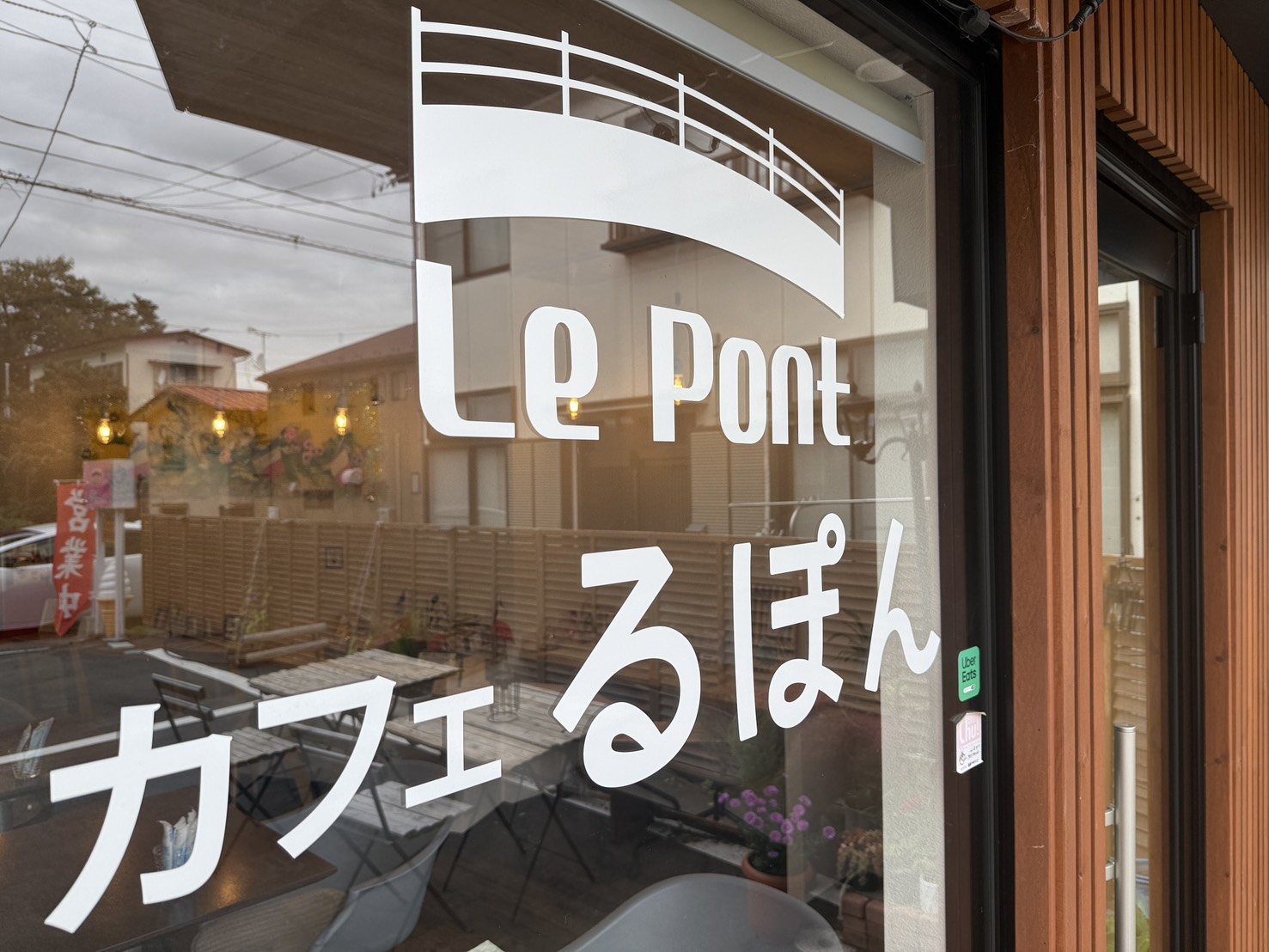 窓ガラスに描かれた Le Pont の白いロゴと、ガラス越しのテラス席
