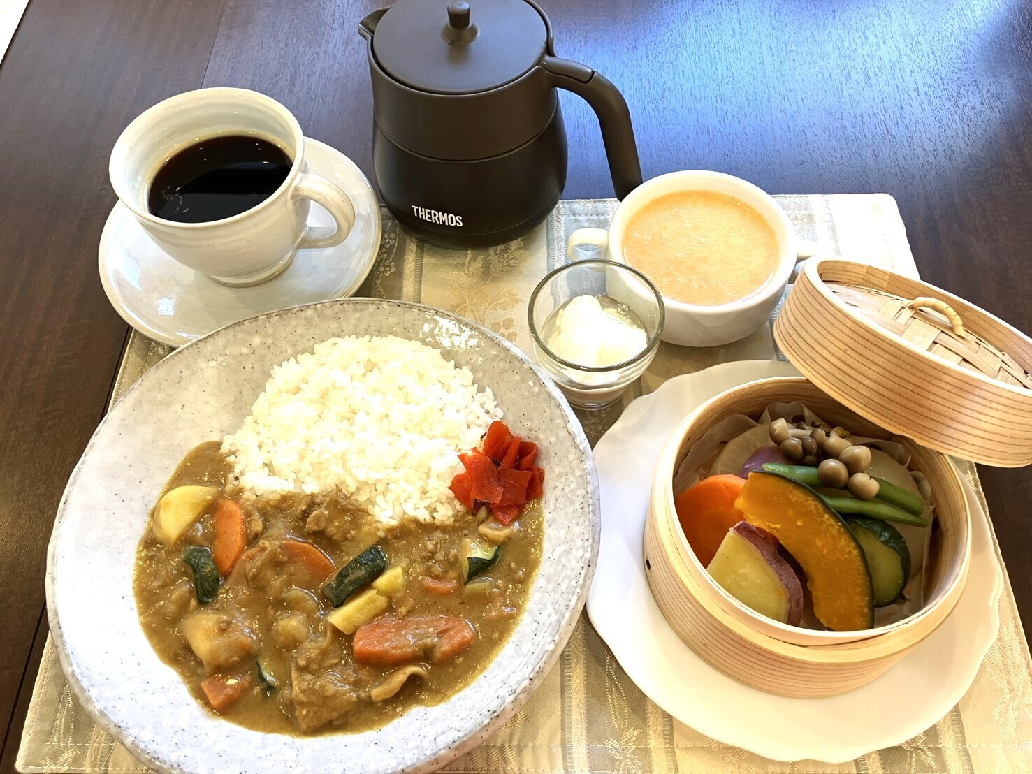 カレーとせいろ蒸しの温野菜、スープ、ドリンクを添えたカレーセット